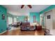 Open concept living room leading to kitchen and dining area, featuring teal walls and hardwood floors at 725 Chelton Ln, Fort Mill, SC 29715