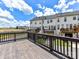 A wooden deck with railing offers outdoor space with a view of green space and the surrounding townhome community at 7518 Turley Ridge Ln, Charlotte, NC 28273