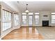 Spacious living room with hardwood floors, large windows, and cozy fireplace at 7518 Turley Ridge Ln, Charlotte, NC 28273