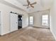 Bright main bedroom with a ceiling fan, recessed ceilings, and a sliding barn door to the ensuite at 7518 Turley Ridge Ln, Charlotte, NC 28273