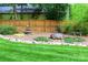 Landscaped backyard featuring river rock borders, a stone fountain, wood fence, and manicured lawn at 802 E Franklin St, Monroe, NC 28112