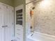 Elegant bathroom featuring marble-tiled walls, a shower with multiple heads, and built in shelves at 802 E Franklin St, Monroe, NC 28112