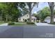 Well-maintained home featuring lush landscaping, a long driveway, and a detached garage at 802 E Franklin St, Monroe, NC 28112