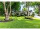 Inviting home featuring a lush green lawn, mature trees, and manicured landscaping at 802 E Franklin St, Monroe, NC 28112
