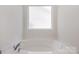 Clean bathtub with chrome faucet fixtures and frosted window at 9416 Cotton Gum Rd, Charlotte, NC 28227