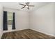 Spacious bedroom with wood-look floors, ceiling fan, and window with curtains at 9416 Cotton Gum Rd, Charlotte, NC 28227