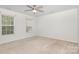 Bright, carpeted bedroom with natural light from multiple windows and a ceiling fan at 9416 Cotton Gum Rd, Charlotte, NC 28227