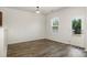 Open living room space with neutral walls, hardwood floors, and door to back deck at 9416 Cotton Gum Rd, Charlotte, NC 28227