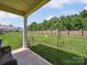 Spacious backyard with well-maintained lawn, brick wall, and partial covered patio at 9428 Carneros Creek Rd, Charlotte, NC 28214