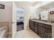 The bathroom features a granite double vanity, tile floor, and doorway to the Primary bedroom at 9428 Carneros Creek Rd, Charlotte, NC 28214