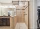 A tiled shower with a glass door, shelving and granite vanity is featured in this bathroom at 9428 Carneros Creek Rd, Charlotte, NC 28214