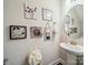Stylish half bathroom featuring a pedestal sink, decorative mirror, and tastefully arranged wall art at 9428 Carneros Creek Rd, Charlotte, NC 28214