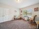 Cozy bedroom featuring comfortable seating, natural light from the window, and neutral decor at 9428 Carneros Creek Rd, Charlotte, NC 28214