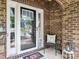 Inviting entryway with a welcome sign, decorative wreath, and charming chair on a brick-paved porch at 9428 Carneros Creek Rd, Charlotte, NC 28214