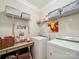Neat laundry room with overhead storage, countertops, decor, and modern washer and dryer at 9428 Carneros Creek Rd, Charlotte, NC 28214
