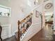 Elegant staircase with decorative floral arrangements and a view into a sunlit living space at 9428 Carneros Creek Rd, Charlotte, NC 28214
