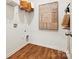 Bright laundry room with wooden floors, white walls, and wooden storage basket on a shelf at 1070 Bull Dog Ln, Wingate, NC 28174