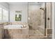 Bright bathroom features a tiled soaking tub and a separate glass shower enclosure at 109 Trent Pines Dr, Mooresville, NC 28117