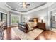 Spacious main bedroom with tray ceilings, hardwood floors, and a large bed, with lots of natural light at 109 Trent Pines Dr, Mooresville, NC 28117