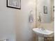 Half bathroom featuring pedestal sink, framed mirror, and decorative artwork at 1210 Tabitha Ct, Monroe, NC 28110