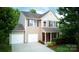 Two-story home with a two-car garage, cozy front porch, manicured bushes, and a well-kept lawn at 1210 Tabitha Ct, Monroe, NC 28110
