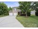 Charming two-story home featuring a two-car garage, well-manicured lawn, and mature trees at 1210 Tabitha Ct, Monroe, NC 28110