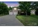 Charming two-story home at twilight featuring a two-car garage, well-manicured lawn, and mature trees at 1210 Tabitha Ct, Monroe, NC 28110