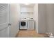 Bright laundry room features tile floors, a shelving rack and a full-size washer and dryer set at 1210 Tabitha Ct, Monroe, NC 28110