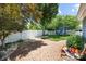 Landscaped backyard featuring a white fence, brick paver area, lush greenery and a trampoline at 126 Blandina Ct, Fort Mill, SC 29708