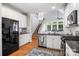 Bright kitchen with white cabinets, black appliances, granite countertops, hardwood floors, and staircase at 126 Blandina Ct, Fort Mill, SC 29708