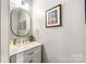 Well-lit powder room featuring a marble countertop vanity and decorative mirror at 126 Blandina Ct, Fort Mill, SC 29708