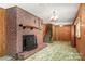 Large basement with a brick fireplace, wooden shelves, and carpeted flooring at 128 Howie St, Mount Holly, NC 28120