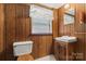 A half bathroom featuring wood paneled walls, commode, and a vanity at 128 Howie St, Mount Holly, NC 28120