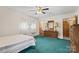 Bedroom with ceiling fan, bed, dresser with mirror, window, and green carpet at 128 Howie St, Mount Holly, NC 28120