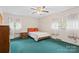 Bedroom with twin beds, ceiling fan, two windows with sheer white curtains, and green carpet at 128 Howie St, Mount Holly, NC 28120