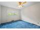 Bedroom with a window for natural light, ceiling fan, and blue carpet at 128 Howie St, Mount Holly, NC 28120