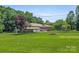 The lush front yard features a fire pit and a charming brick home at 128 Howie St, Mount Holly, NC 28120