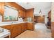 Well-lit kitchen featuring wooden cabinets, a sink, and a view into the living room with fireplace at 128 Howie St, Mount Holly, NC 28120