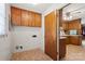 Functional laundry room with wood cabinets and vinyl flooring, next to the kitchen at 128 Howie St, Mount Holly, NC 28120