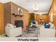 Virtually staged living room with a brick fireplace, comfortable seating, and neutral decor at 128 Howie St, Mount Holly, NC 28120