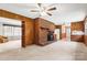 Spacious living room boasts a brick fireplace, wood paneling, ceiling fan, and carpeted floors at 128 Howie St, Mount Holly, NC 28120