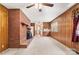 Bright living room with fireplace, wood paneling, ceiling fan, and entry to the kitchen at 128 Howie St, Mount Holly, NC 28120
