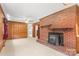 Cozy living room shows fireplace and wood paneling with carpeted floors and a ceiling fan at 128 Howie St, Mount Holly, NC 28120