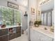 Bright bathroom featuring a large window, linen storage, and a white vanity with ample counter space at 130 Nims Spring Dr, Fort Mill, SC 29715