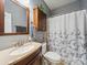 Cozy bathroom features a vanity with granite top, mirror, and shower with blue floral shower curtain at 130 Nims Spring Dr, Fort Mill, SC 29715