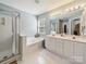 Bright bathroom featuring a walk-in shower, soaking tub, double sink vanity, and a large window at 130 Nims Spring Dr, Fort Mill, SC 29715