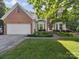 Charming two-story traditional-style home with a brick facade, attached garage, and manicured lawn at 130 Nims Spring Dr, Fort Mill, SC 29715