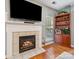 Inviting living room features a cozy fireplace with tile surround and built-in shelves for storage at 130 Nims Spring Dr, Fort Mill, SC 29715