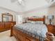 Spacious primary bedroom featuring a wooden bed frame, tray ceiling, and an en suite bathroom at 130 Nims Spring Dr, Fort Mill, SC 29715
