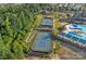 Aerial view of tennis courts and pool surrounded by lush greenery, enhancing community appeal at 1335 Bryson Gap Dr, Fort Mill, SC 29715